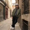 Vero-Lifestyle-Helm-Beige-Beanie-Heren Man leunend tegen een bakstenen muur met een beige beanie fietshelm cover van Vero.